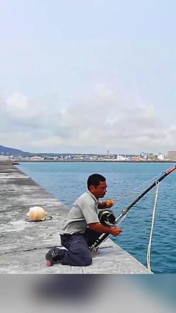Heavy Rock Fishing Enthusiast Intensely Operates His Large Gear: Drum Reel and Rock Fishing